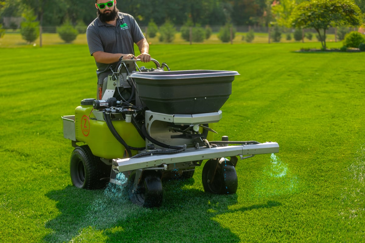 Lawn fertilization service applying treatment to healthy green grass in Aurora Illinois